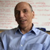 Dan French sitting in a chair with a marker board behind him